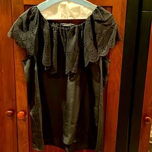 BCBGMAXAZRIA black sleeveless top with cutout overlay.